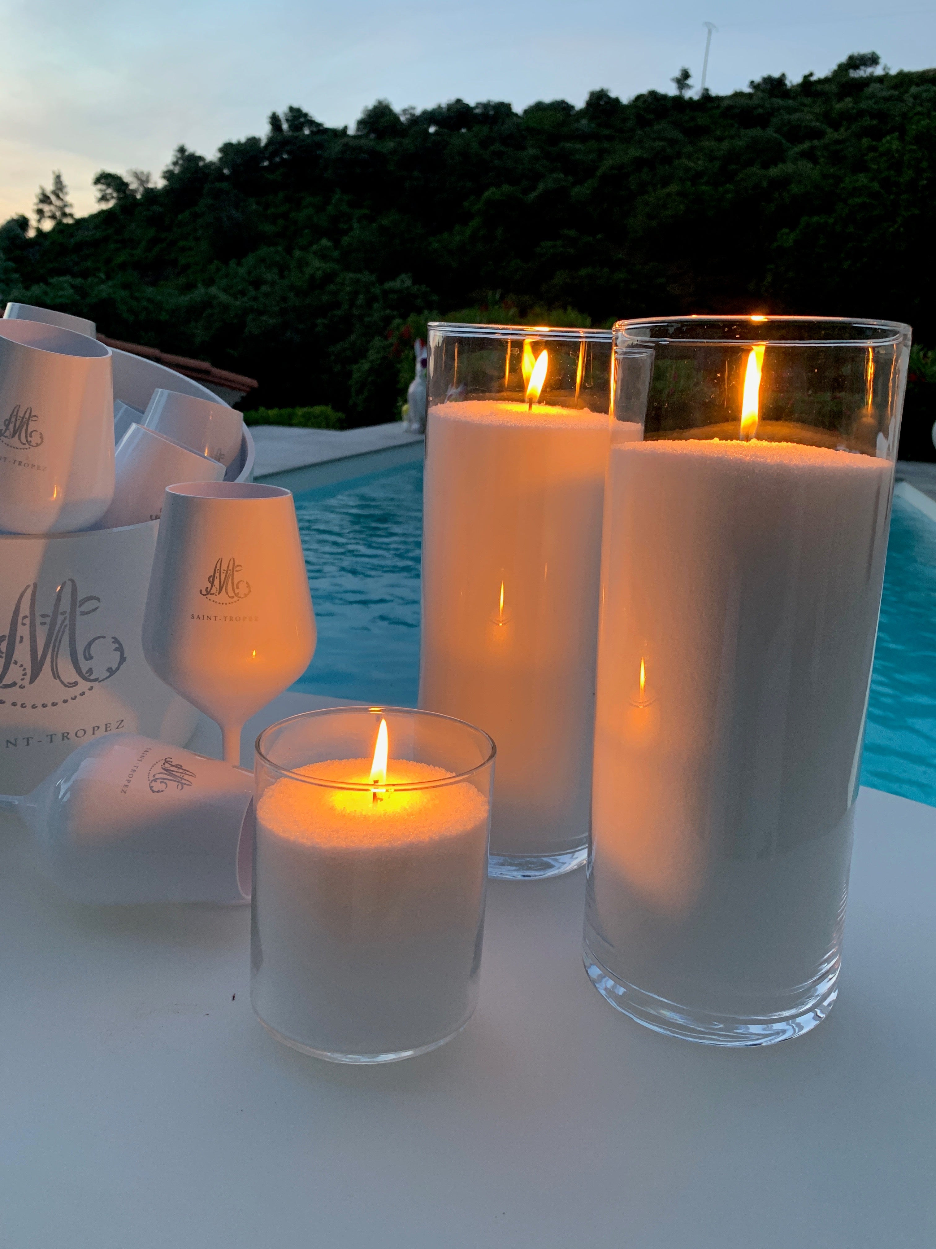 Bougie en perles Blanc Pur Maison Charlee au bord d’une piscine, cire végétale rechargeable dans des contenants en verre