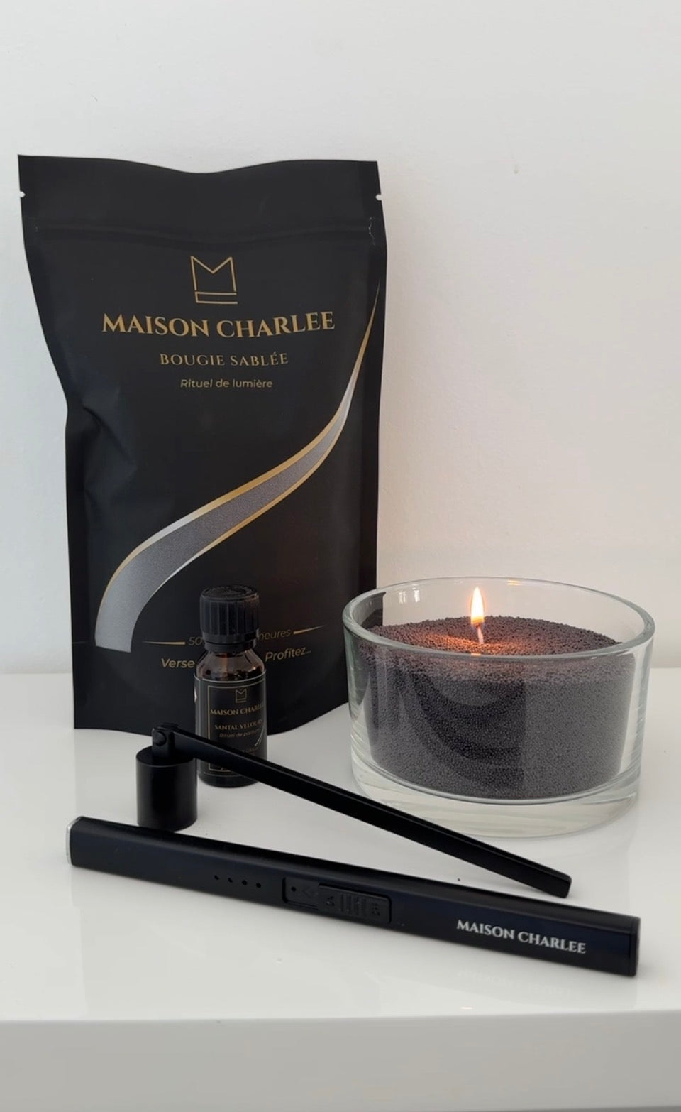  Bougie Noir profond Maison Charlee allumée avec sable de bougie végétal, parfum de Grasse et accessoires Maison Charlee.