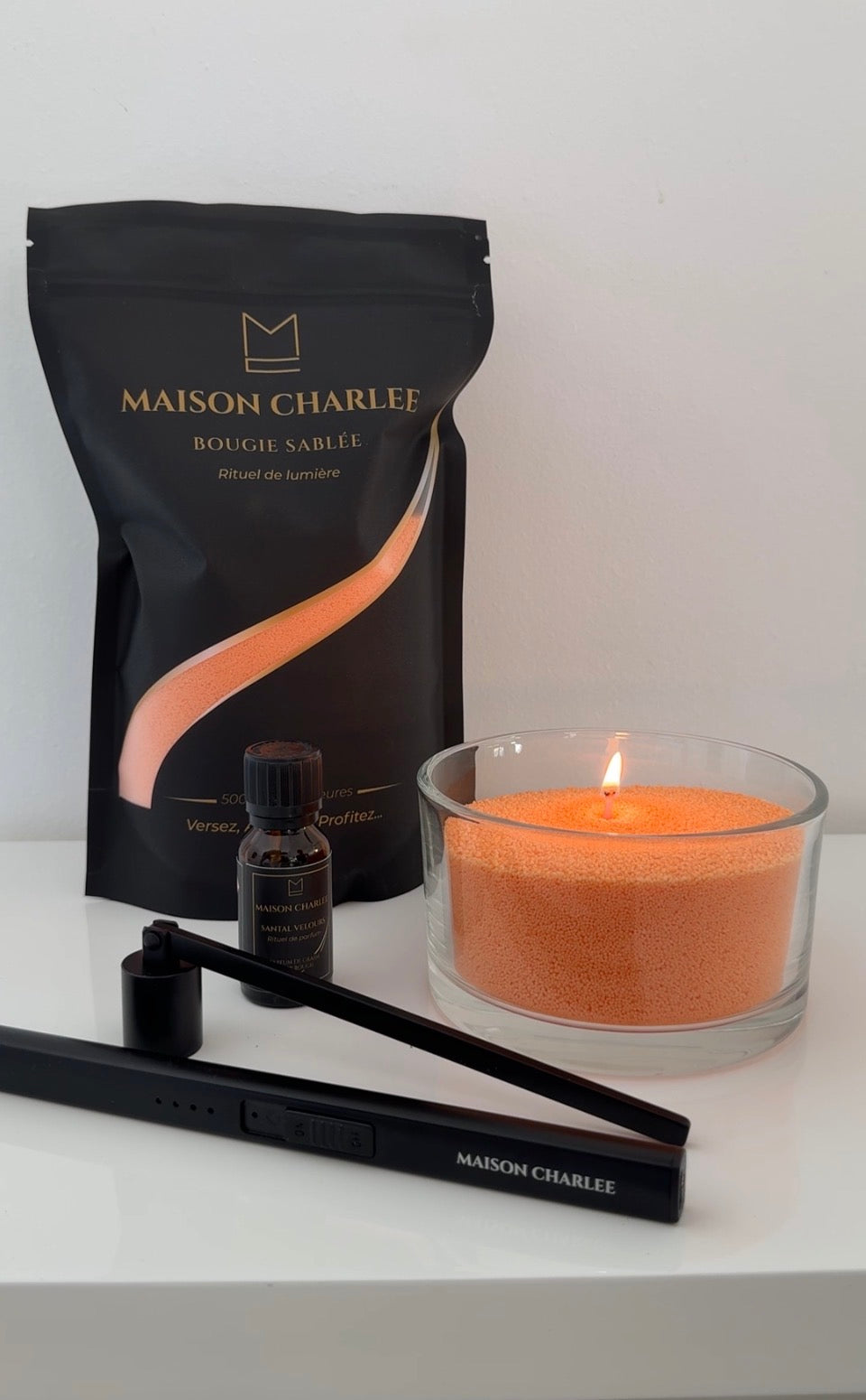 Bougie Orange ambre Maison Charlee allumée avec sable de cire végétale, parfum de Grasse et accessoires Maison Charlee.