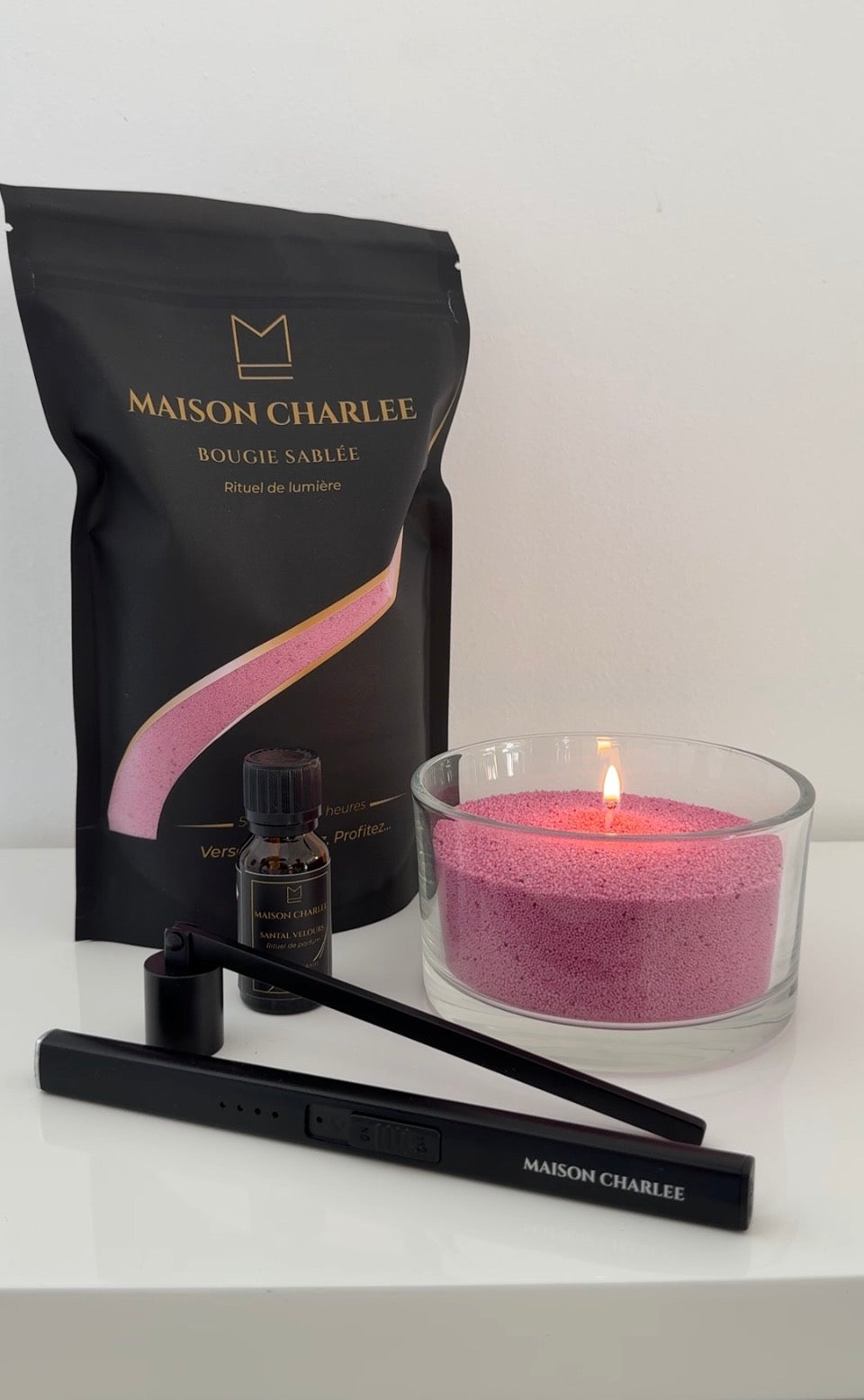 Bougie Rose éclat Maison Charlee allumée avec sable de bougie rechargeable, parfum de Grasse et accessoires.