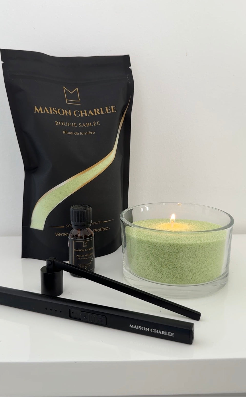 Bougie Vert sauge Maison Charlee allumée avec sable de bougie végétal, parfum de Grasse et accessoires Maison Charlee.
