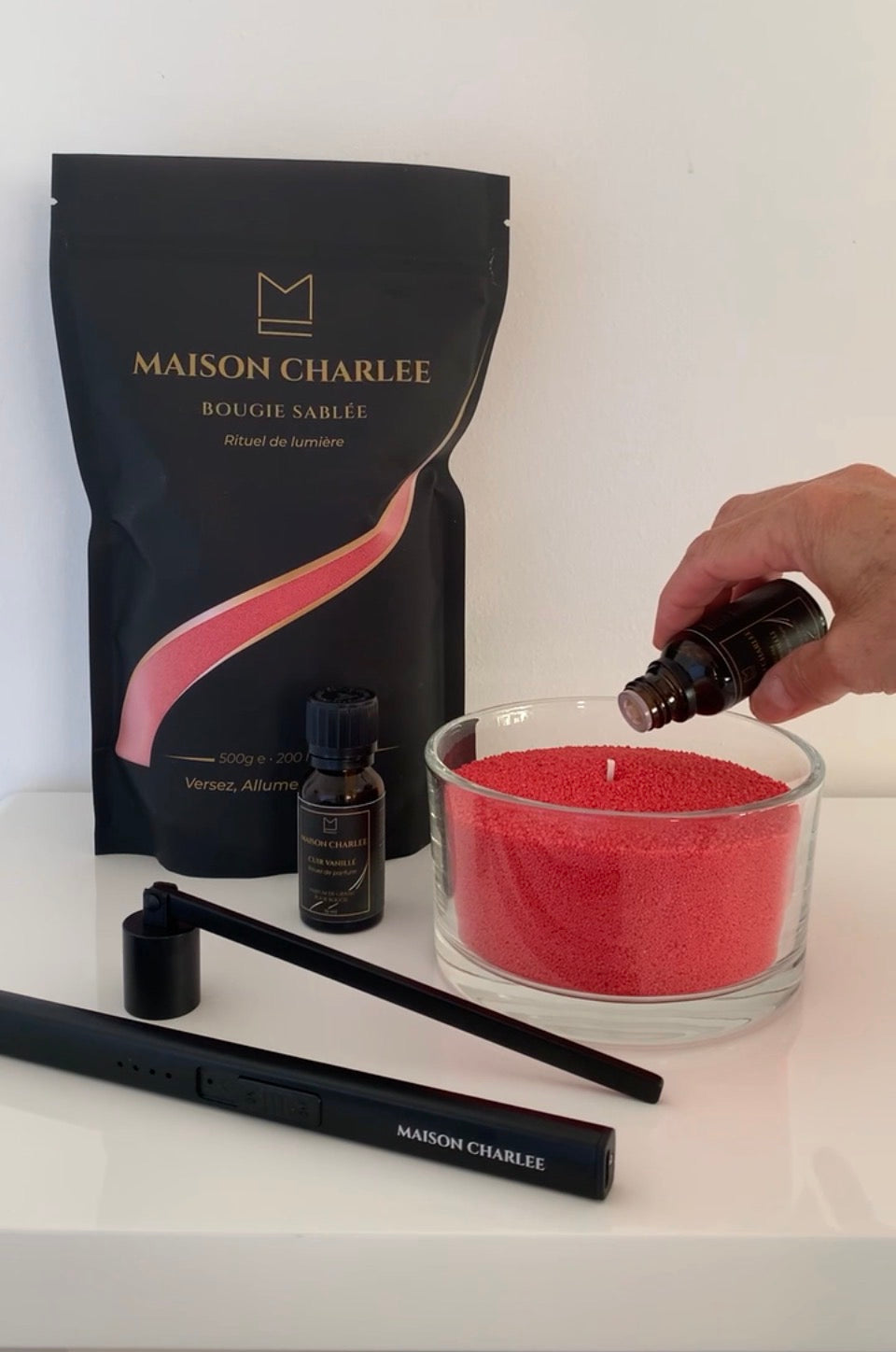 Parfum Ambre Précieux versé dans une bougie Rouge intense en sable de bougie végétal Maison Charlee