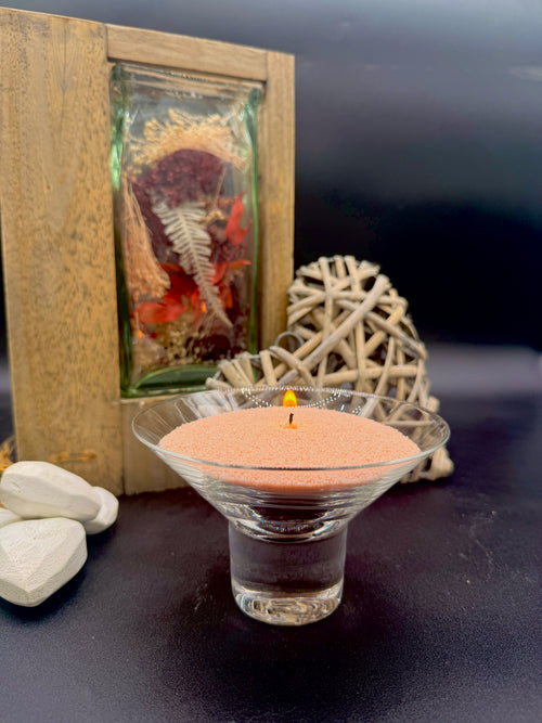 bougie sablée rose dans un verre avec mèche allumée ambiance décorative