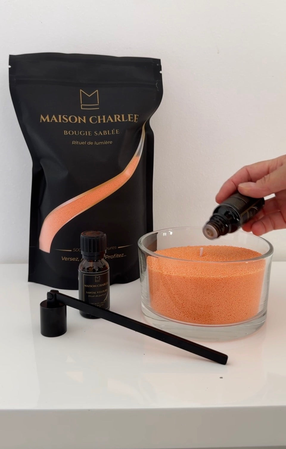 Parfum Santal Velours versé dans une bougie Orange ambre en sable de bougie végétal Maison Charlee